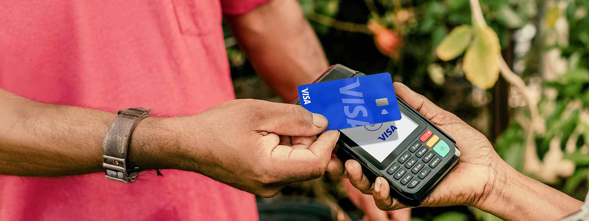 Man tapping to pay with a Visa card.