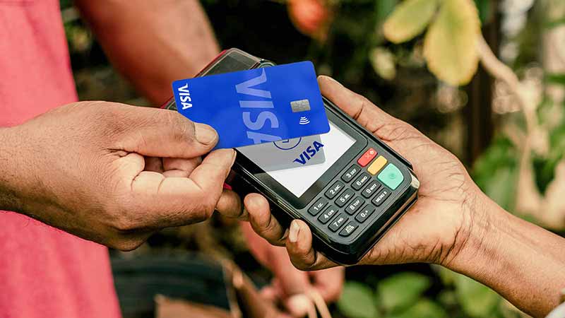 Man tapping to pay with a Visa card.