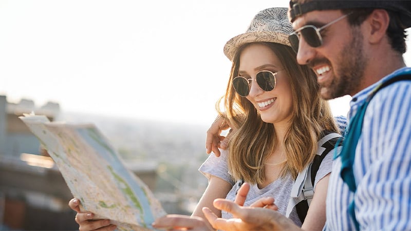 Casal feliz olhando um mapa durante uma viagem